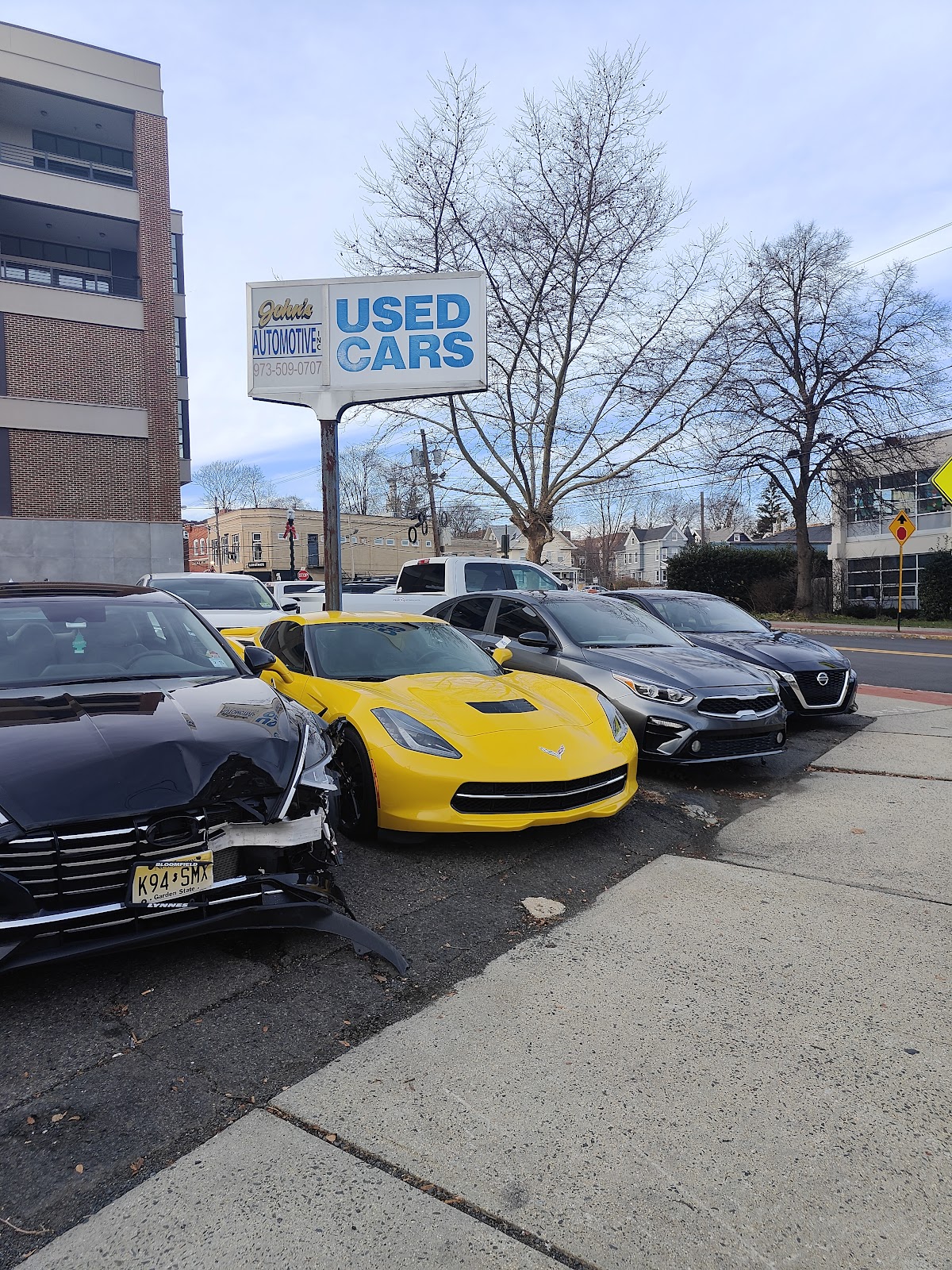 Cars parked under the John’s Automotive street sign