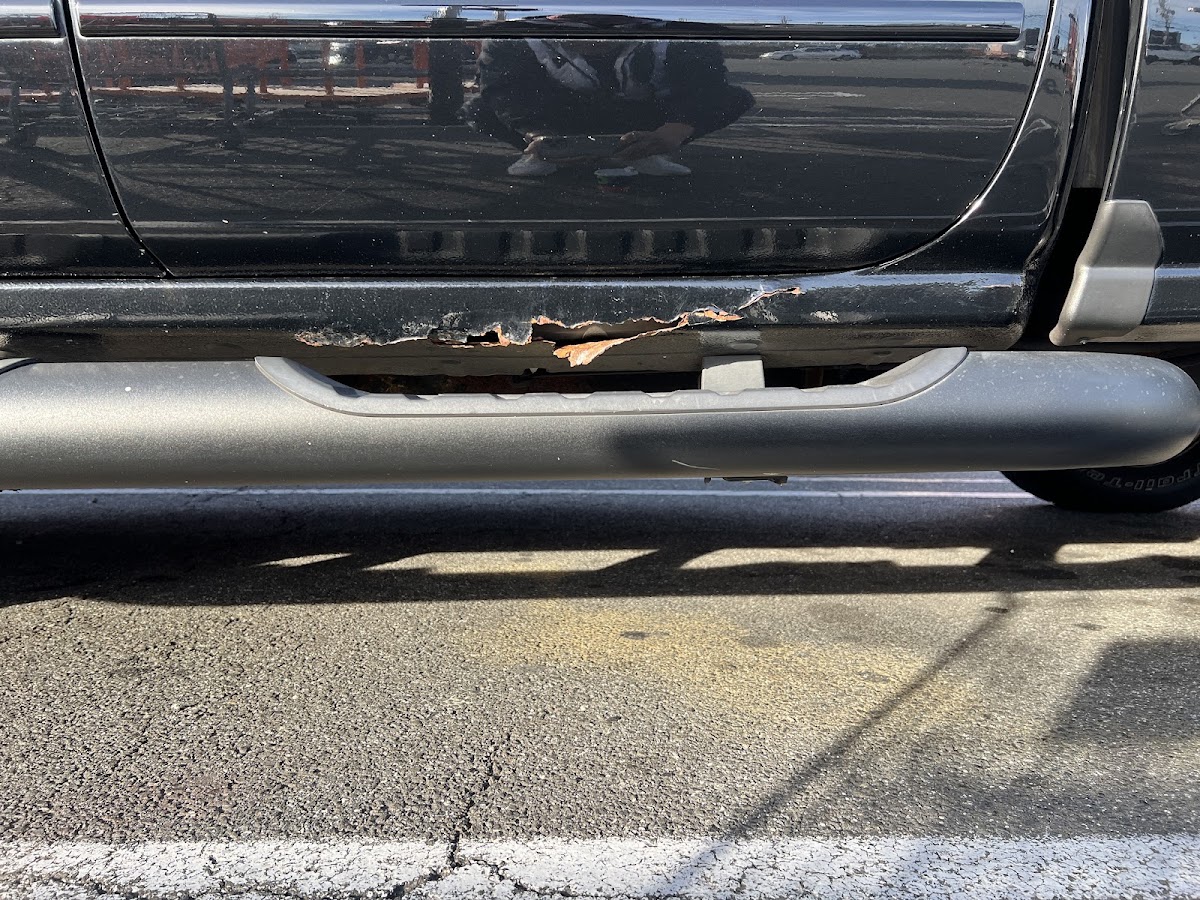 Rust along the rocker panel of a black truck