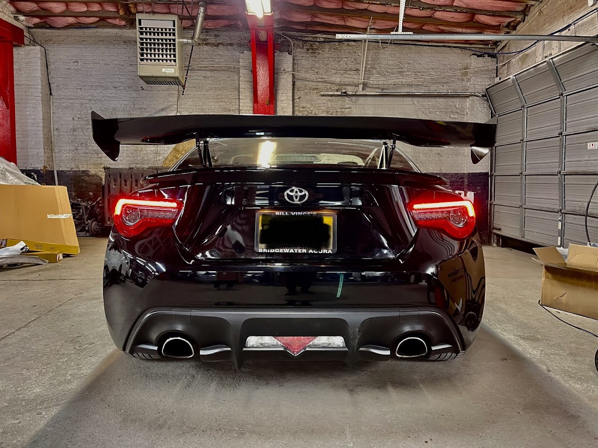 Black Toyota 86 with a rear wing inside the shop
